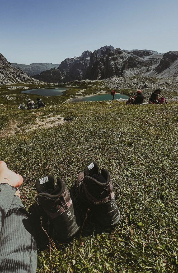 descanso cerca del lago y unas botas de montaña primer plano en dolomitas
